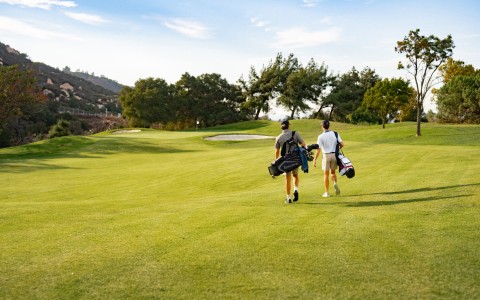 two men walking on a golf course