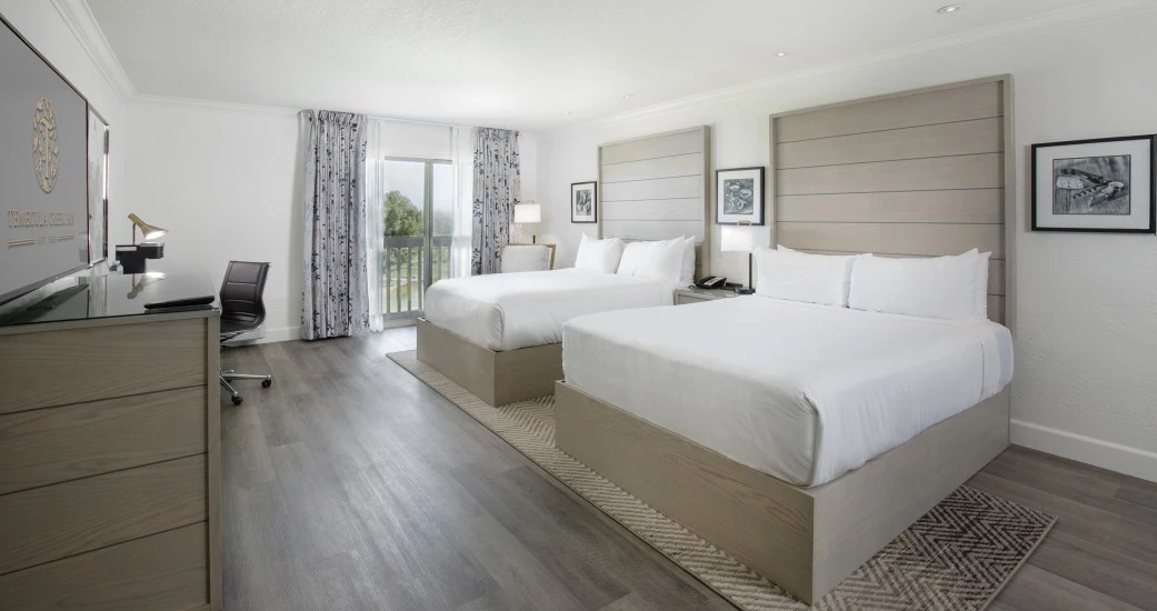 a room with two beds and a desk