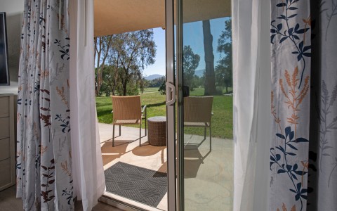 a sliding glass door with a table and chairs outside