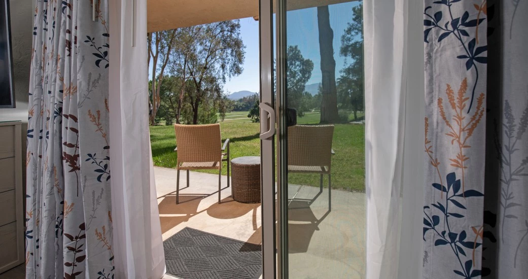 a sliding glass door with a table and chairs outside