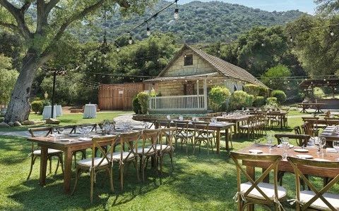 a group of tables and chairs outside a house