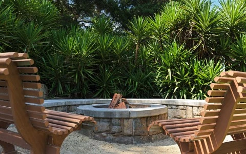 a fire pit with benches in the background