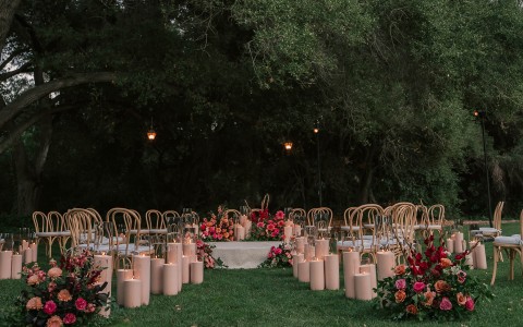 a group of chairs and tables with candles and flowers