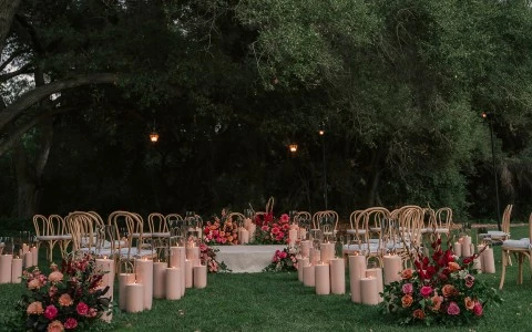 a group of chairs and tables with candles and flowers