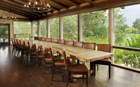 a large table with chairs in a room with windows