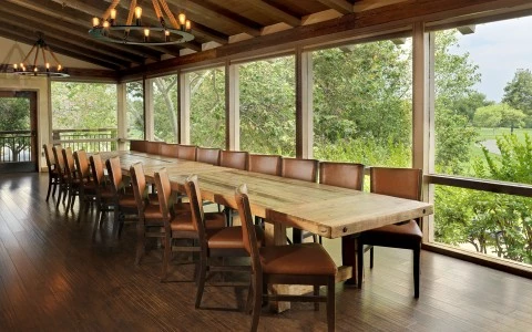 a large table with chairs in a room with windows