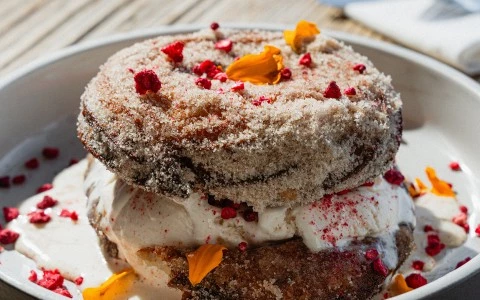 a donut with frosting and toppings on a plate