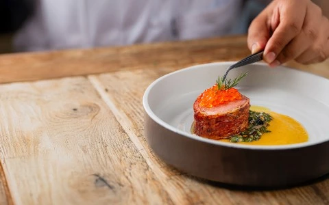 a person holding tweezers over food
