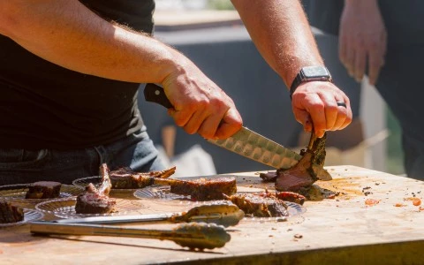 a man cutting meat on a table