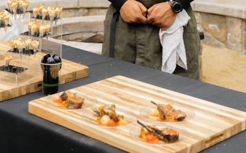 a person standing behind a table with food on plates