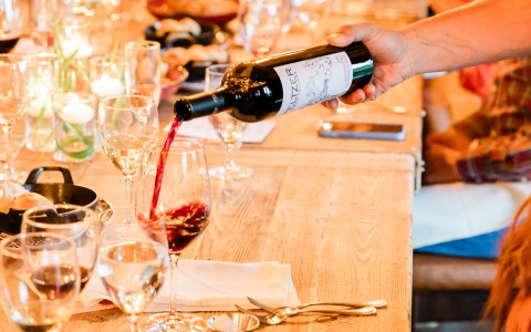 a person pouring wine into a glass