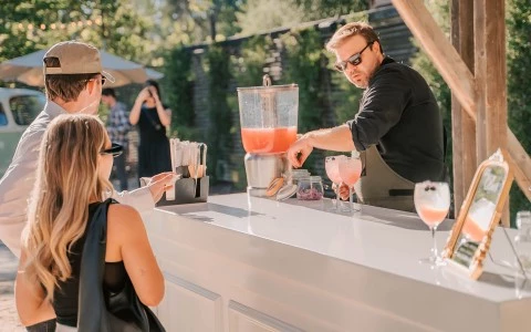 a man pouring a drink into a drink dispenser