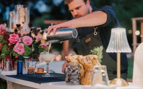 a man pouring a drink into a glass