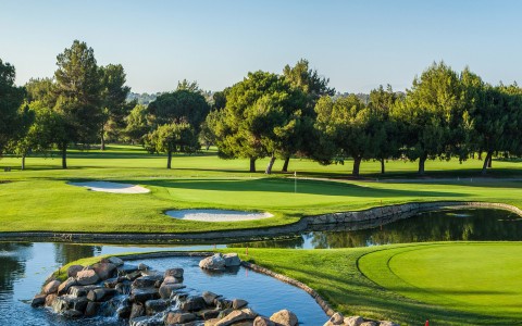 a golf course with a river and trees
