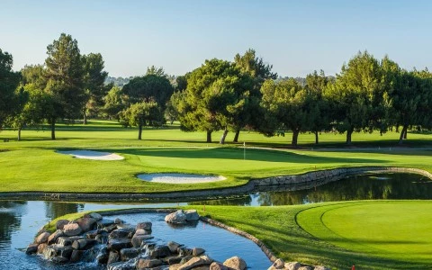 a golf course with a river and trees