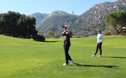 a man swinging a golf club on a golf course