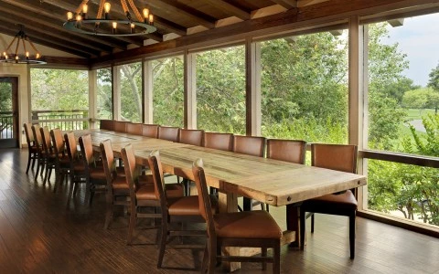 a long table with chairs in a room with windows