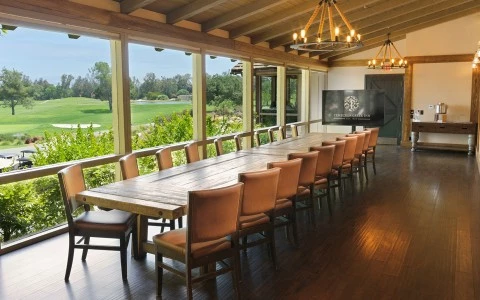 a long table with chairs in a room with a large screen