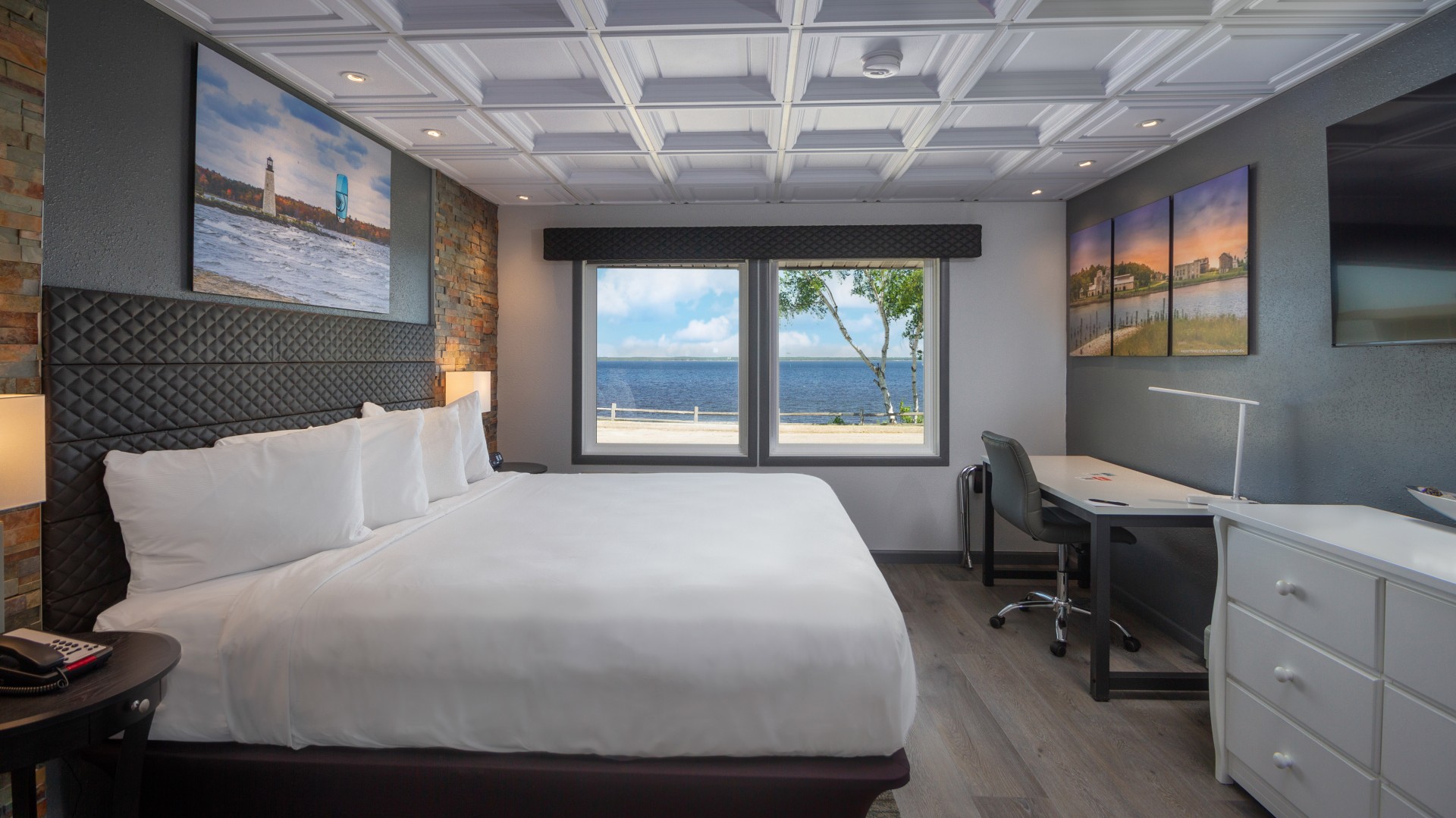 a room with a bed and a desk and a picture on the wall