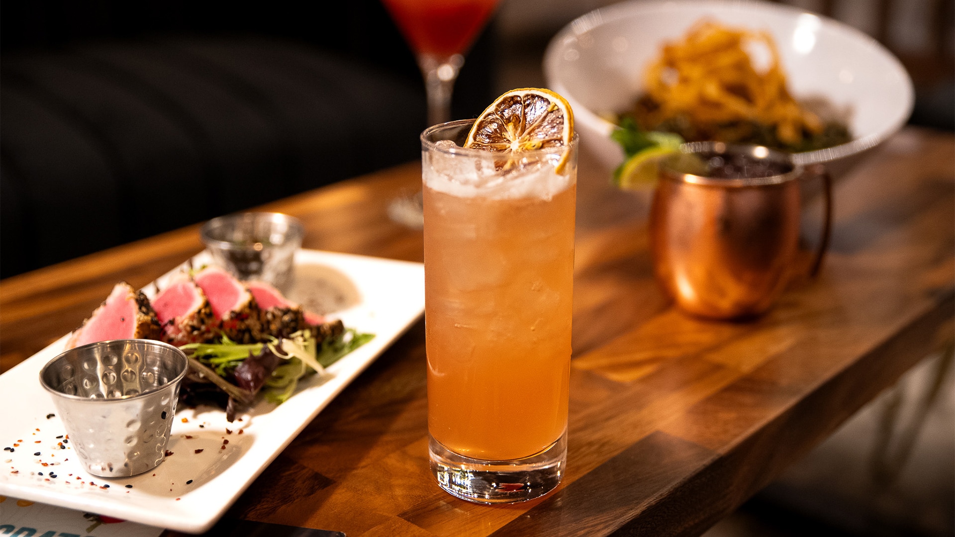 a glass of liquid with a slice of orange on top of it