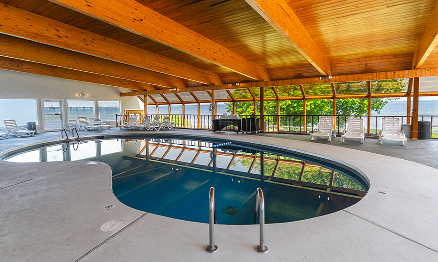 a indoor pool with a deck and chairs