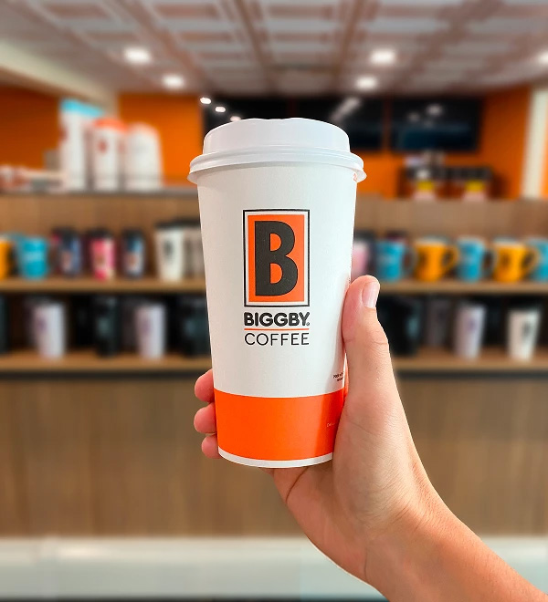 a hand holding a coffee cup