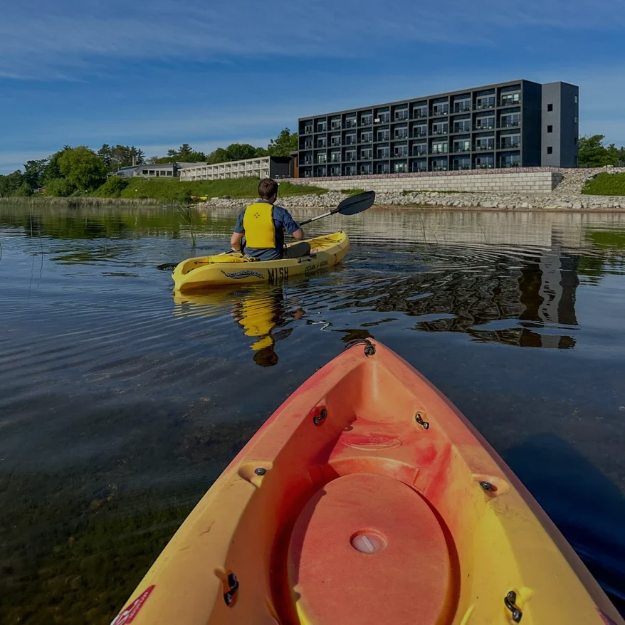 a person in a yellow kayak on a lake