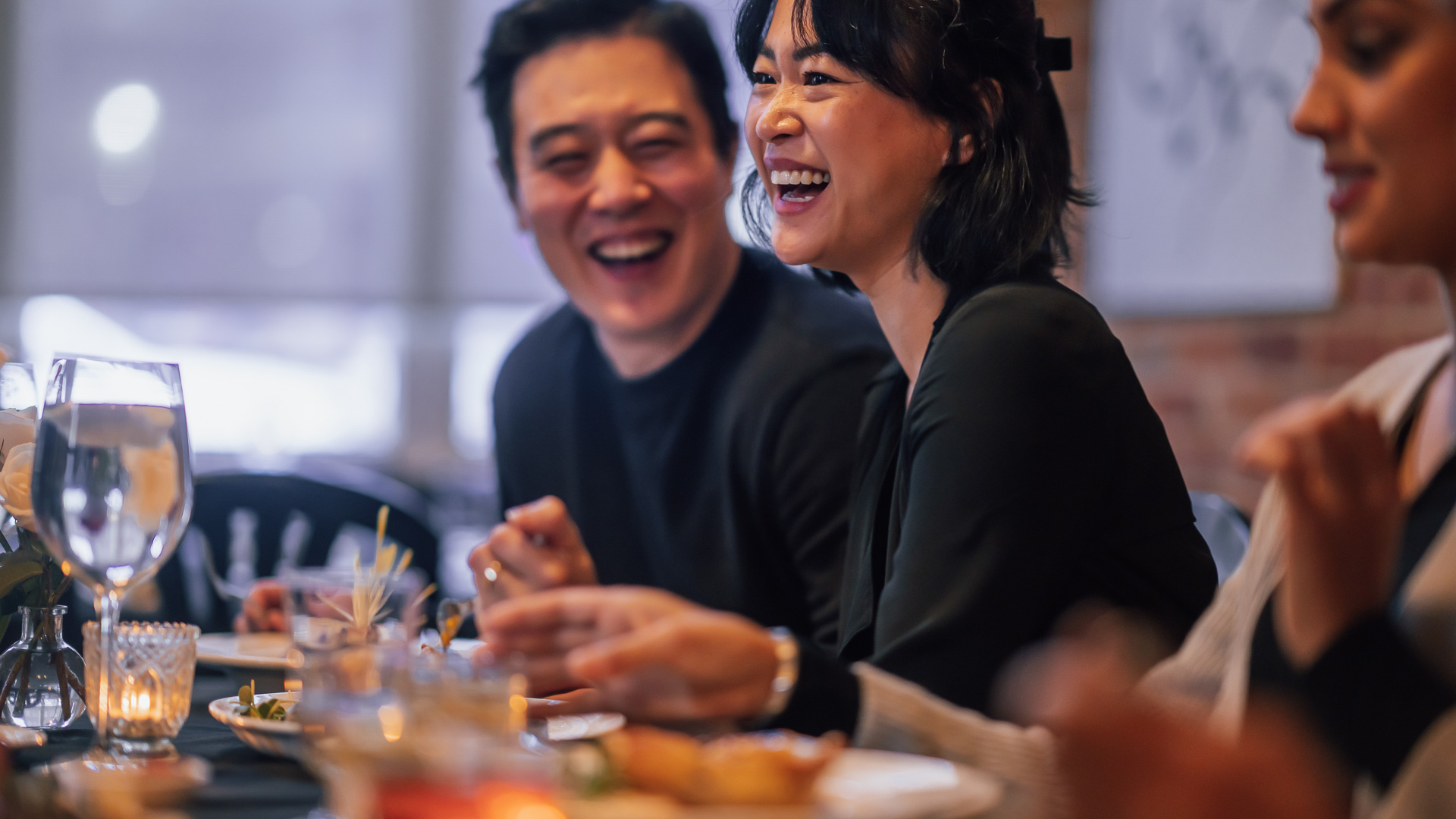 a man and woman laughing at a table