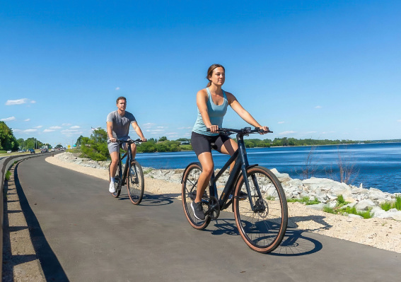 a man and woman riding bikes on a road