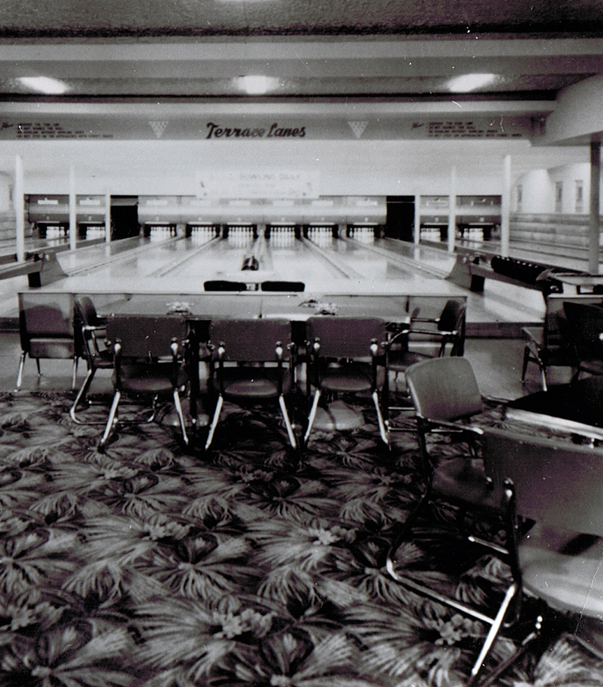 a bowling alley with chairs and a table