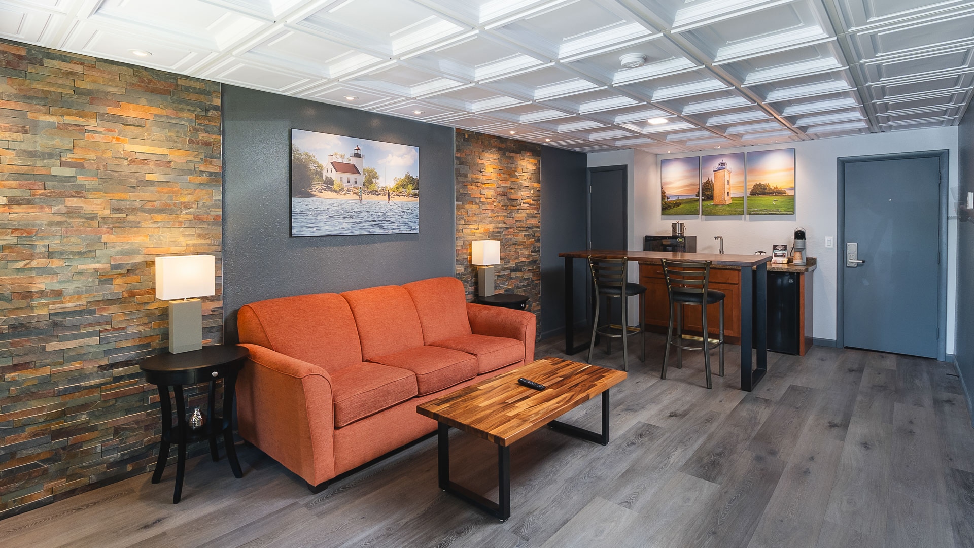 Living area with an orange sofa and a kitchenette