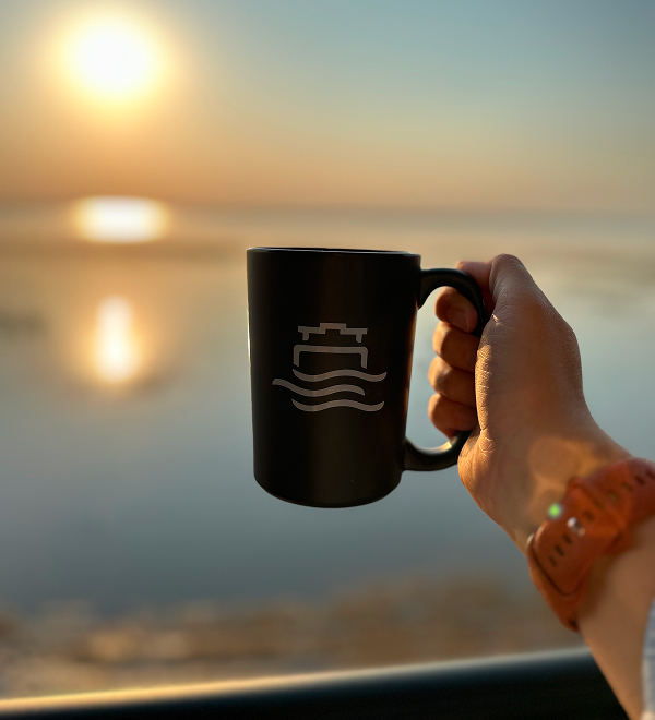 a person holding a black coffee mug