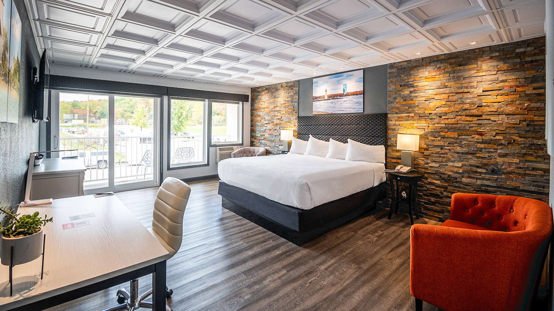 a room with a bed and chairs