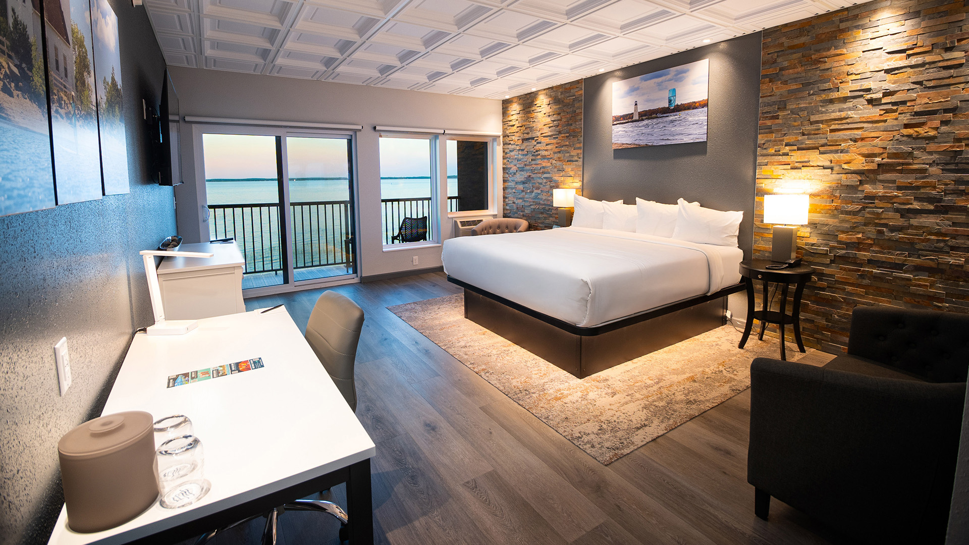 Stylish hotel room with stone accent wall and lakefront balcony view