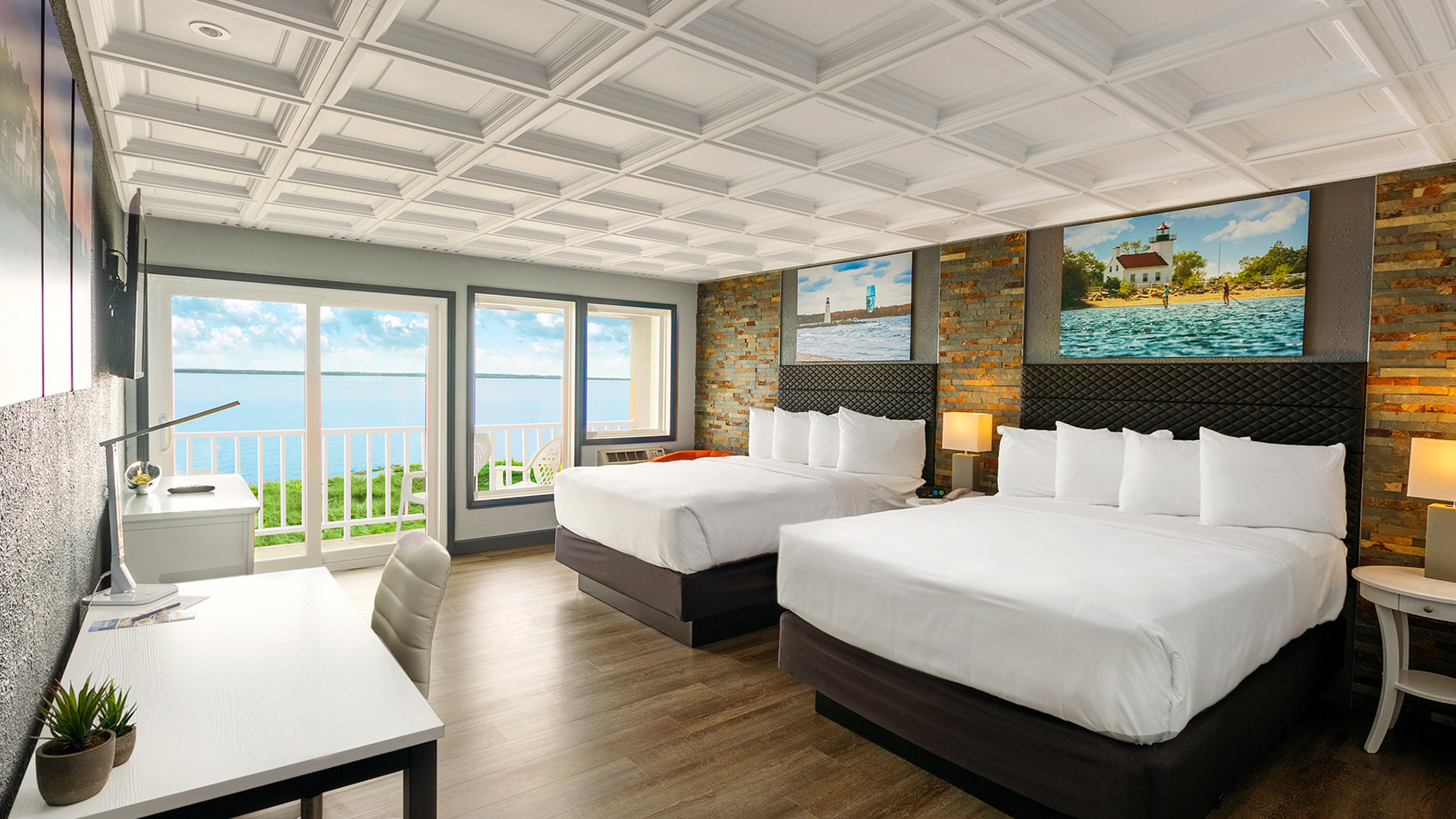 Hotel bedroom with two beds and a balcony overlooking water