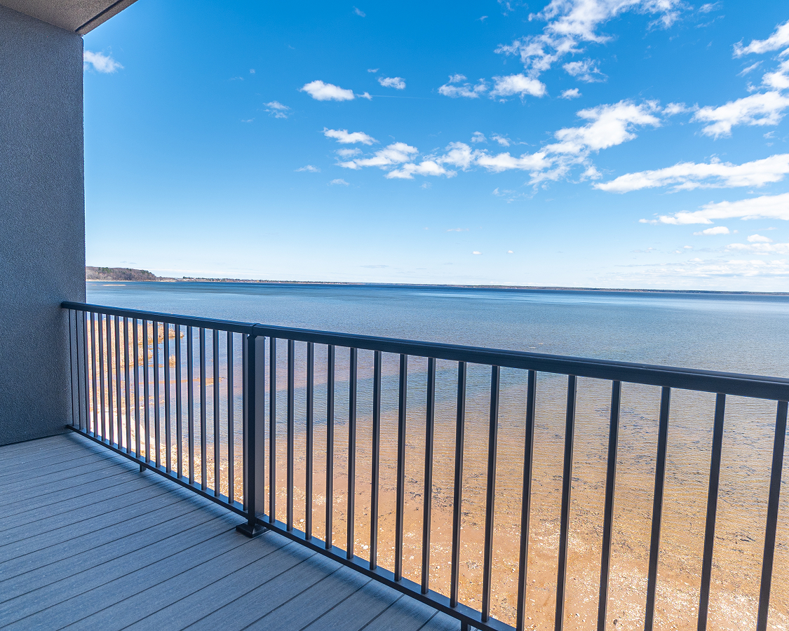 a deck with a railing overlooking a body of water