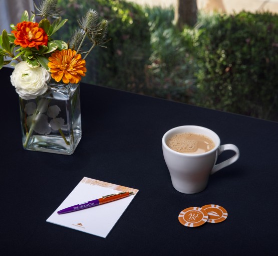 a cup of coffee and a pen and chips on a table gallery