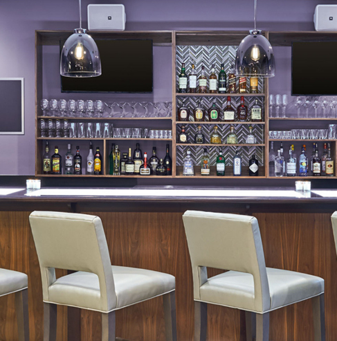 a bar with shelves and chairs