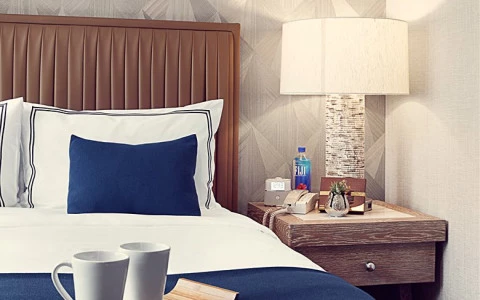 Close up of a queen bed with a nightstand to the right of it. 