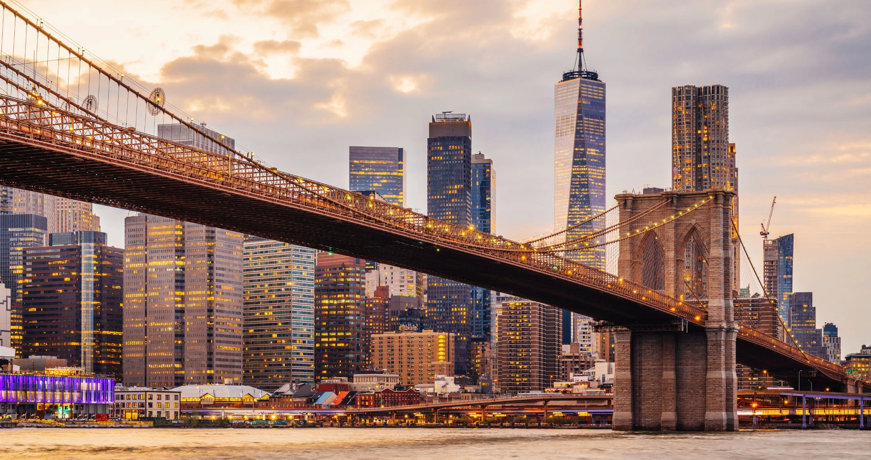a bridge over water with a city in the background
