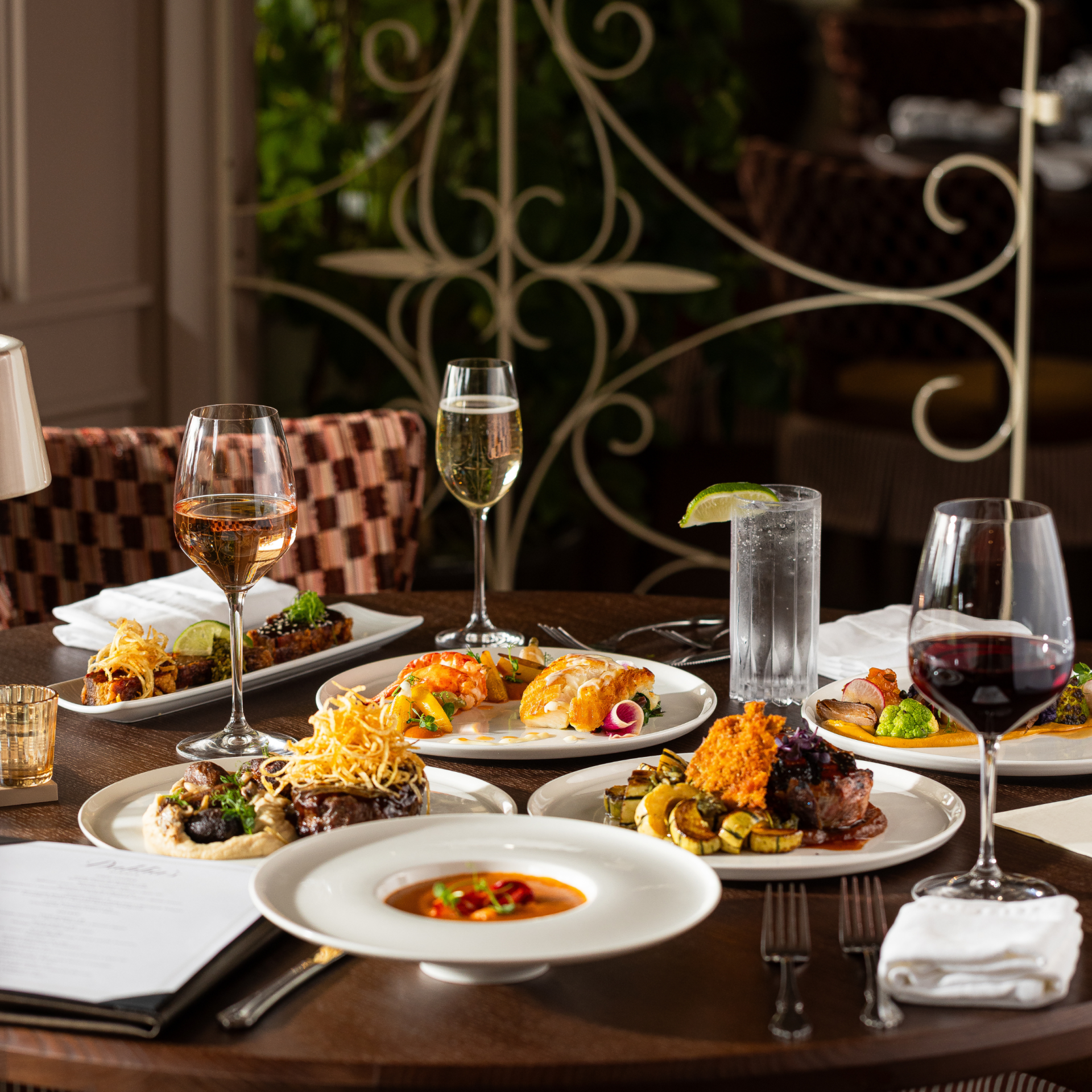 a table with plates of food and wine glasses