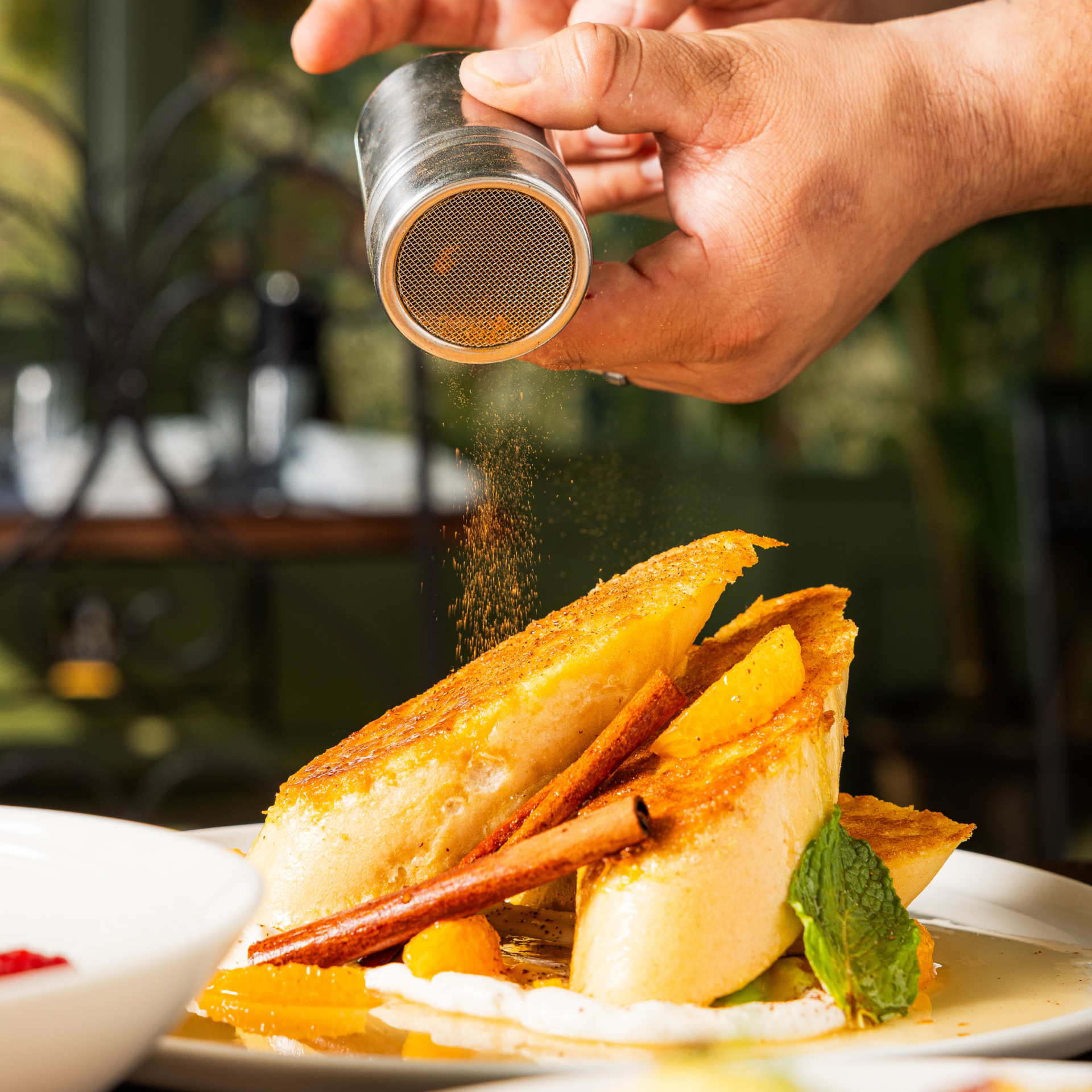 a person sprinkling spices on food