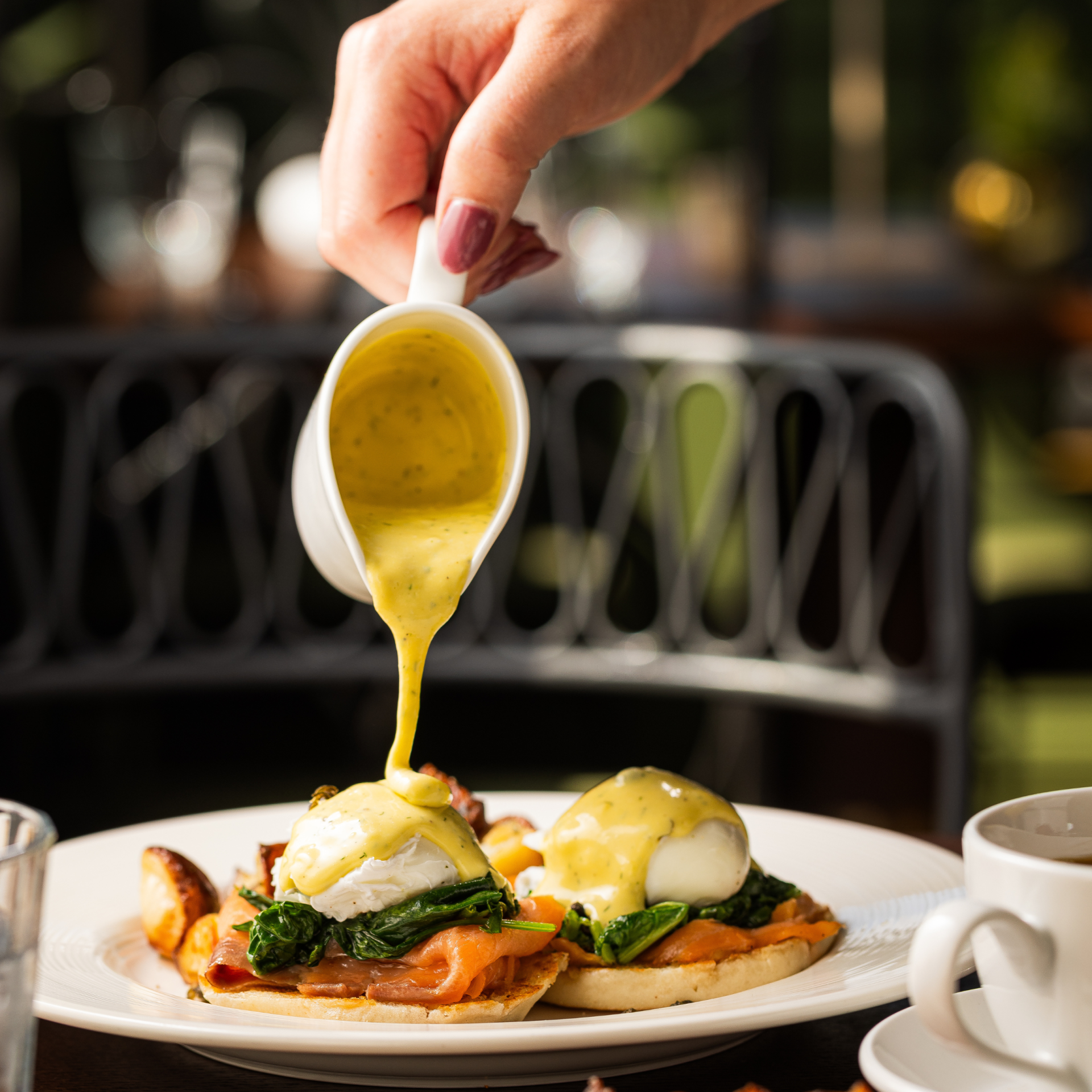 a person pouring sauce on food