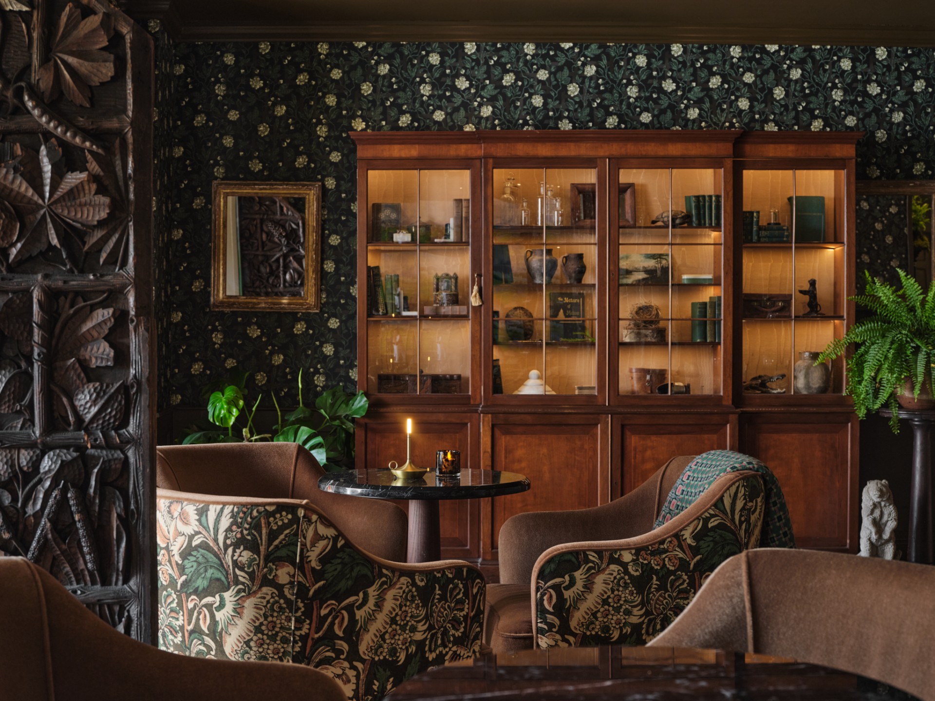 a room with a glass cabinet and chairs