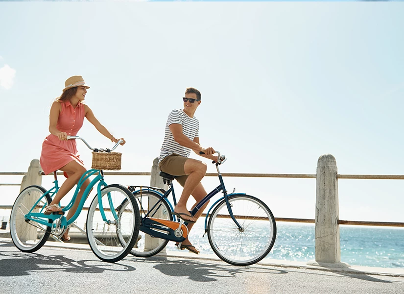 a man and woman riding bicycles on a bridge