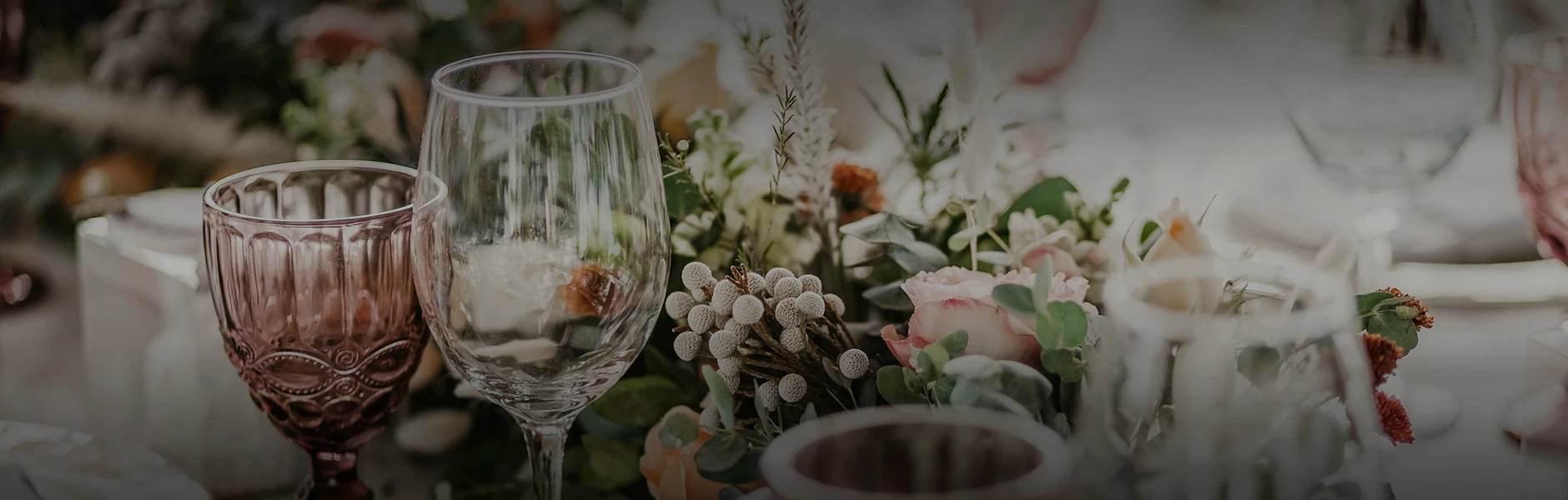 a glass and flowers on a table