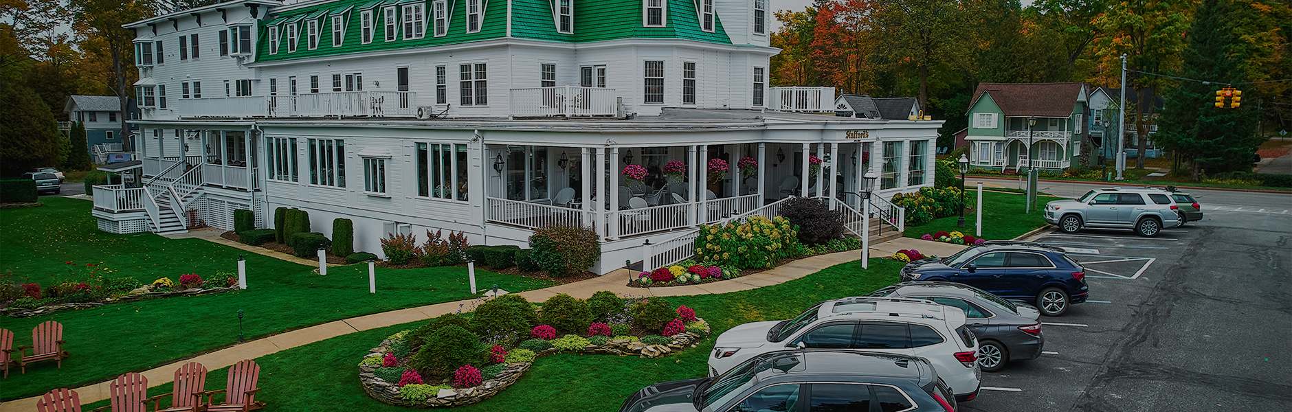 a white house with green roof and white railings
