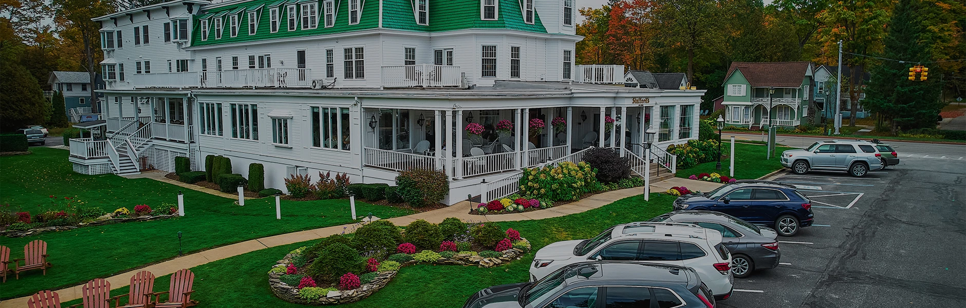 a white house with green roof and white railings