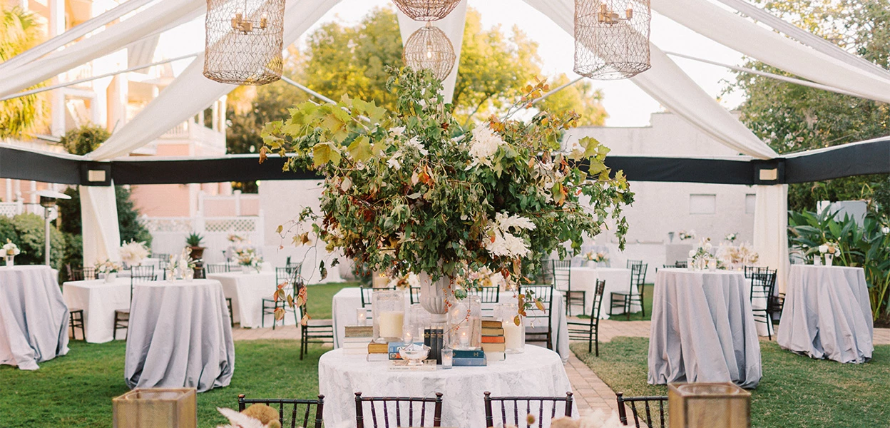 a table set up with a large bouquet of flowers and candles