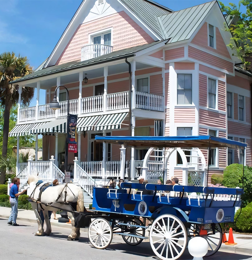 a horse drawn carriage in front of a pink house